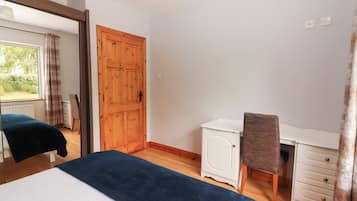 A bedroom with a bed, a desk, and a chair.