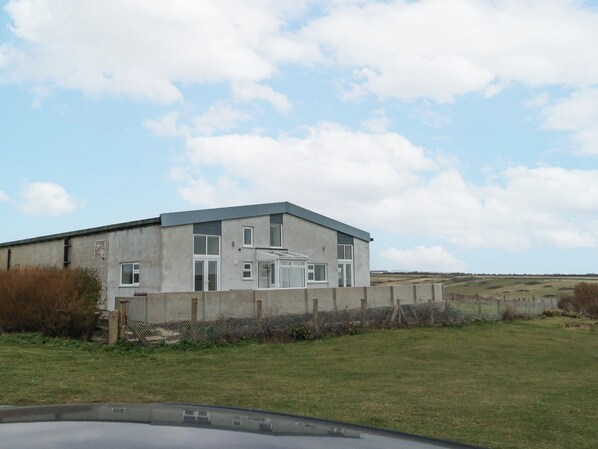 A large, single-story building with a flat roof and a concrete exterior.