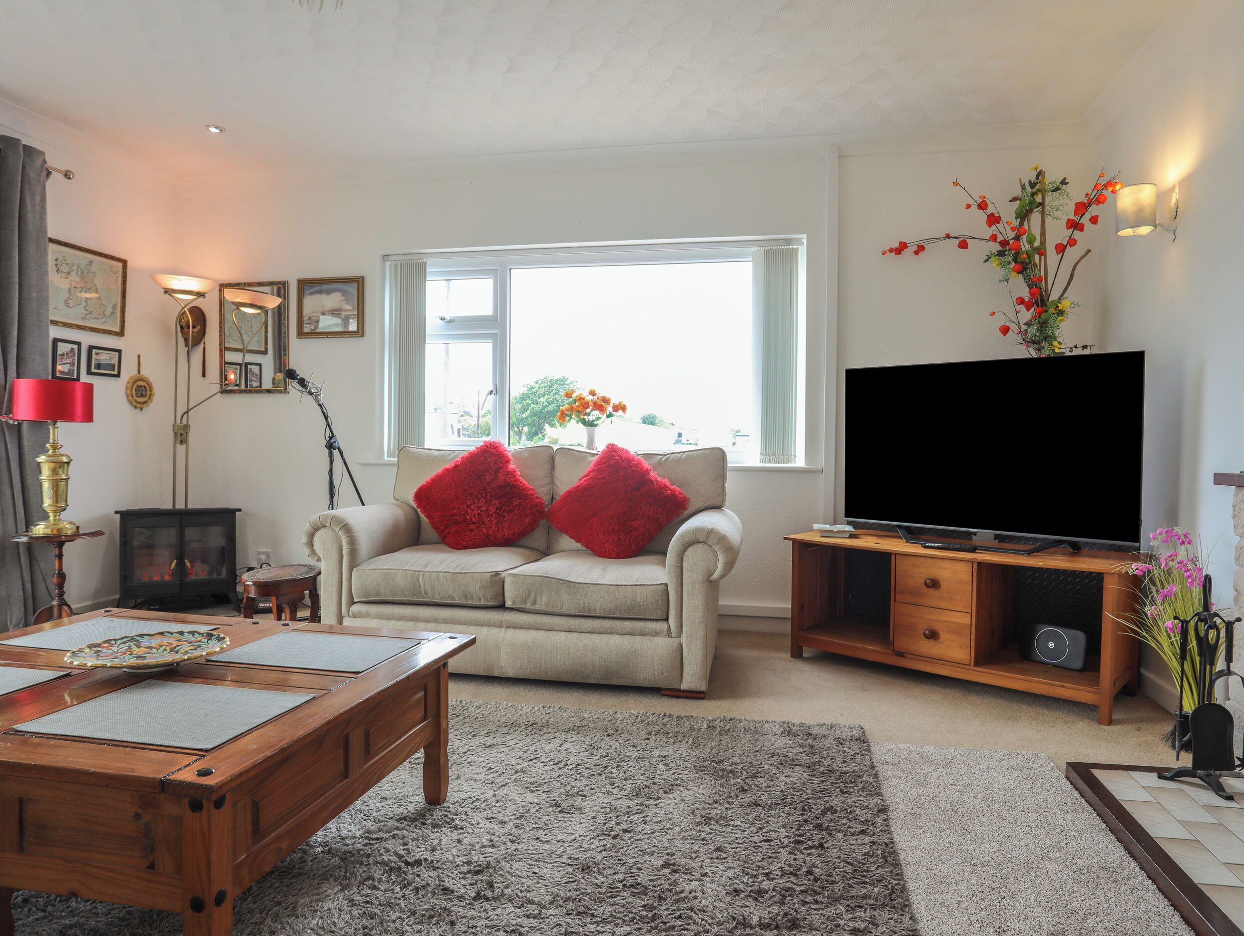 A living room with a sofa, a coffee table, a TV, and a fireplace.