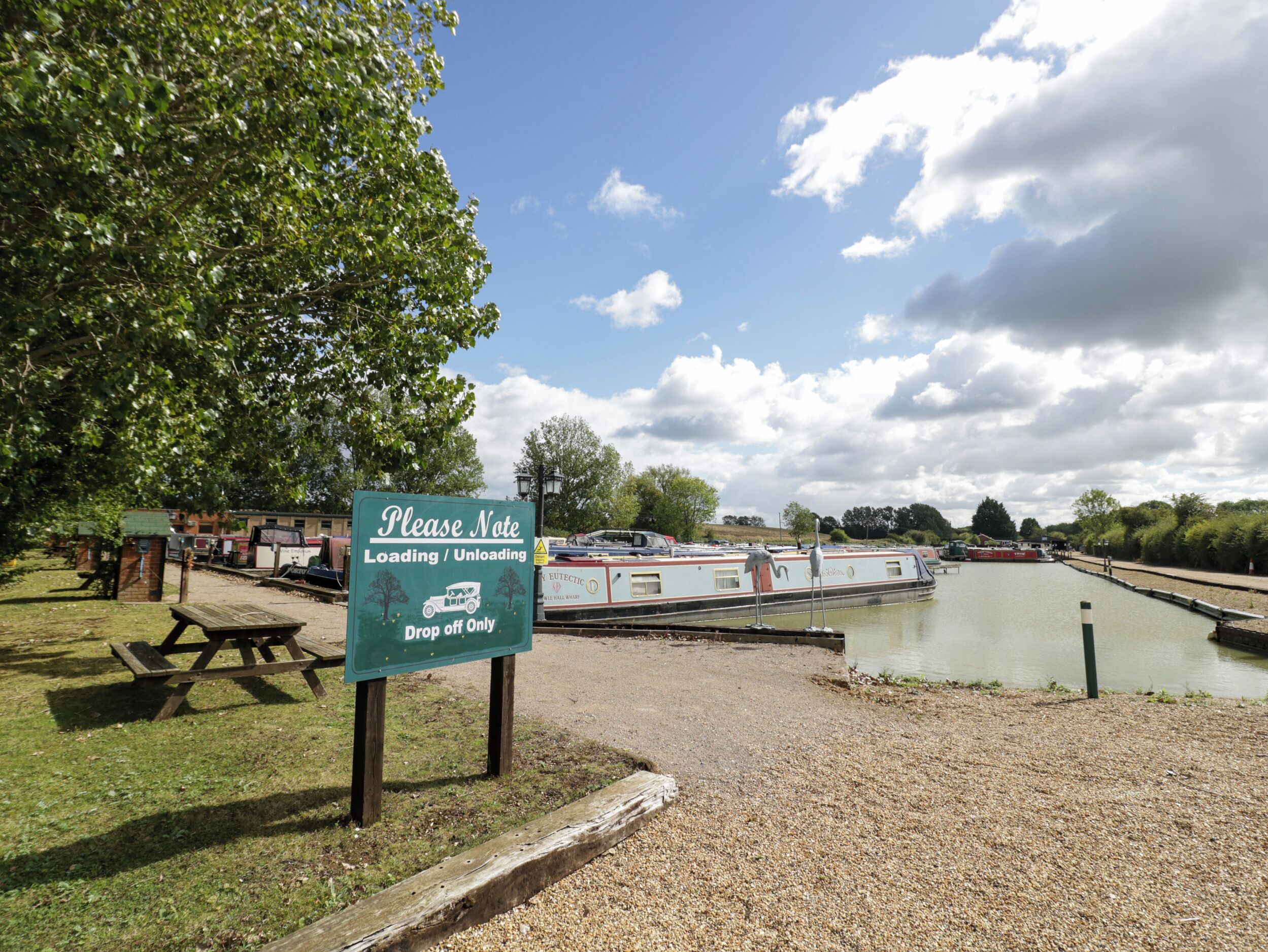 A sign indicating loading/unloading area with a picnic table nearby.