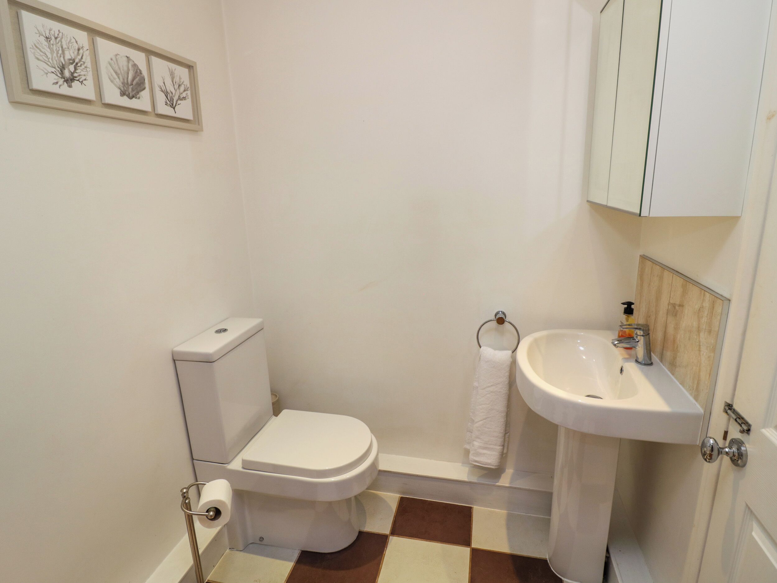 A small bathroom with a toilet, sink, and a towel rack.