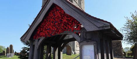 A church with a clock tower and a roof decorated with red flowers.