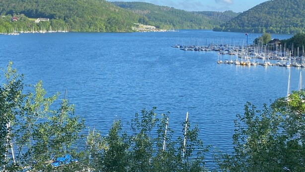 Un lac doté d’un port de plaisance, entouré de collines et d’une végétation clairsemée.