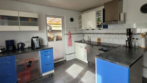 Una cocina moderna con una isla central, armarios blancos y vistas al exterior.