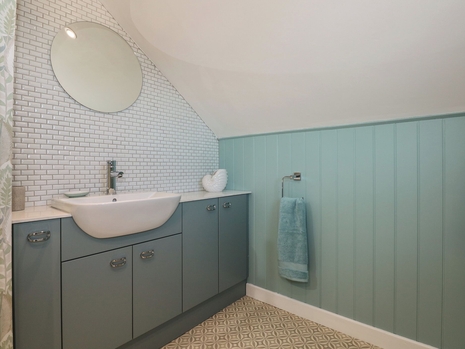 A bathroom with a white sink, a mirror, and a towel rack.