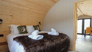 A cozy room with a bed, a fur throw, and two pillows with owl designs. - Barn Owl (Carnforth)