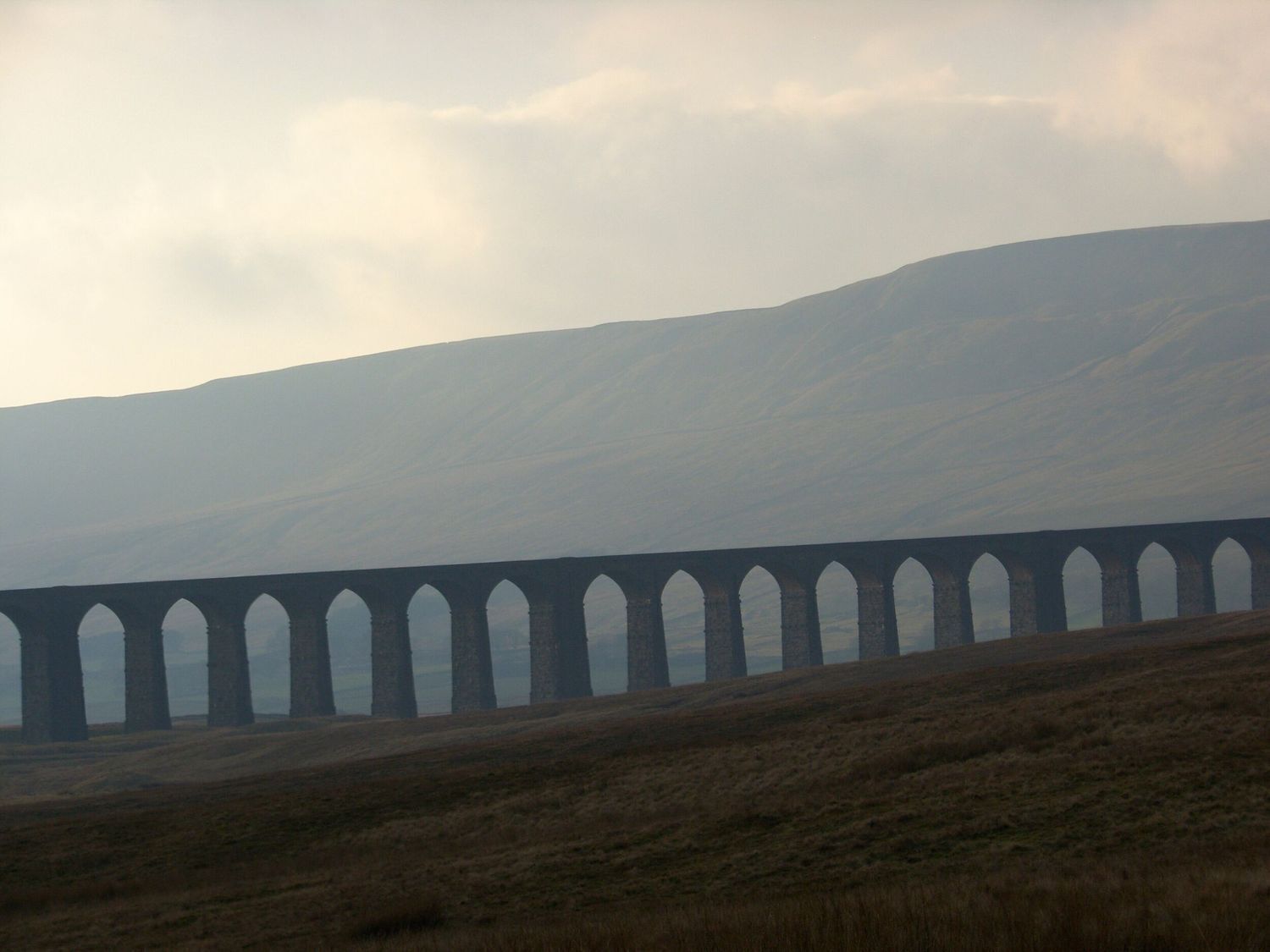 Un viaducte llarg amb diverses voltes que travessa una vall.