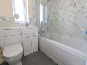 A bathroom with a toilet, a sink, and a glass-enclosed shower area. - 74 Reap Lane (Portland)