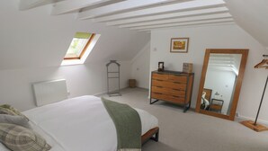 A bedroom with a bed, a dresser, a mirror, and a skylight. - Bryn Siriol (Narberth)