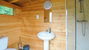 A wooden cabin bathroom with a sink, toilet, and shower. - Hen House @ Penbugle Organic Farm (Liskeard)