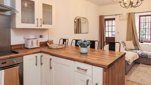 Een moderne keuken met witte kasten, een houten aanrechtblad en een inbouwoven.