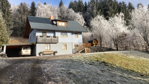 A two-story house with a sloped roof, a front porch, and a garage. - Holiday Home 'Bei Schönwetter' with Mountain View, Private Terrace & Wi-Fi (Bleiberg)