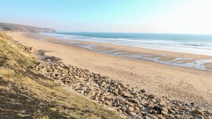 Una spiaggia costiera con un litorale roccioso e una vista limpida sull'oceano.