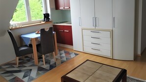 A compact kitchen with a dining area, a window with a view, and a small table.