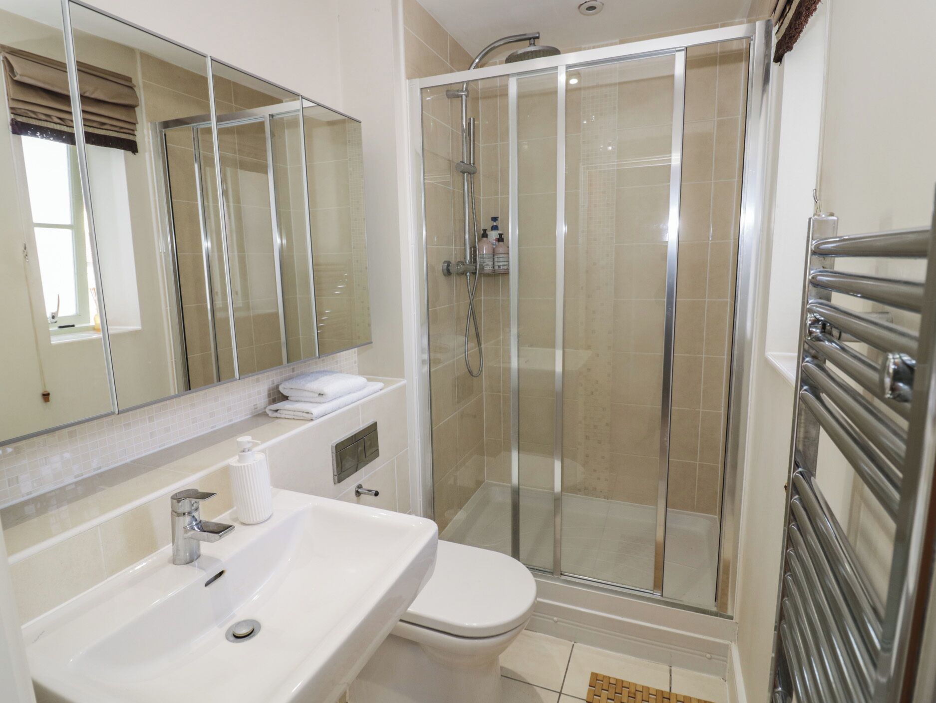 A modern bathroom with a glass-enclosed shower, a white sink, and a toilet.
