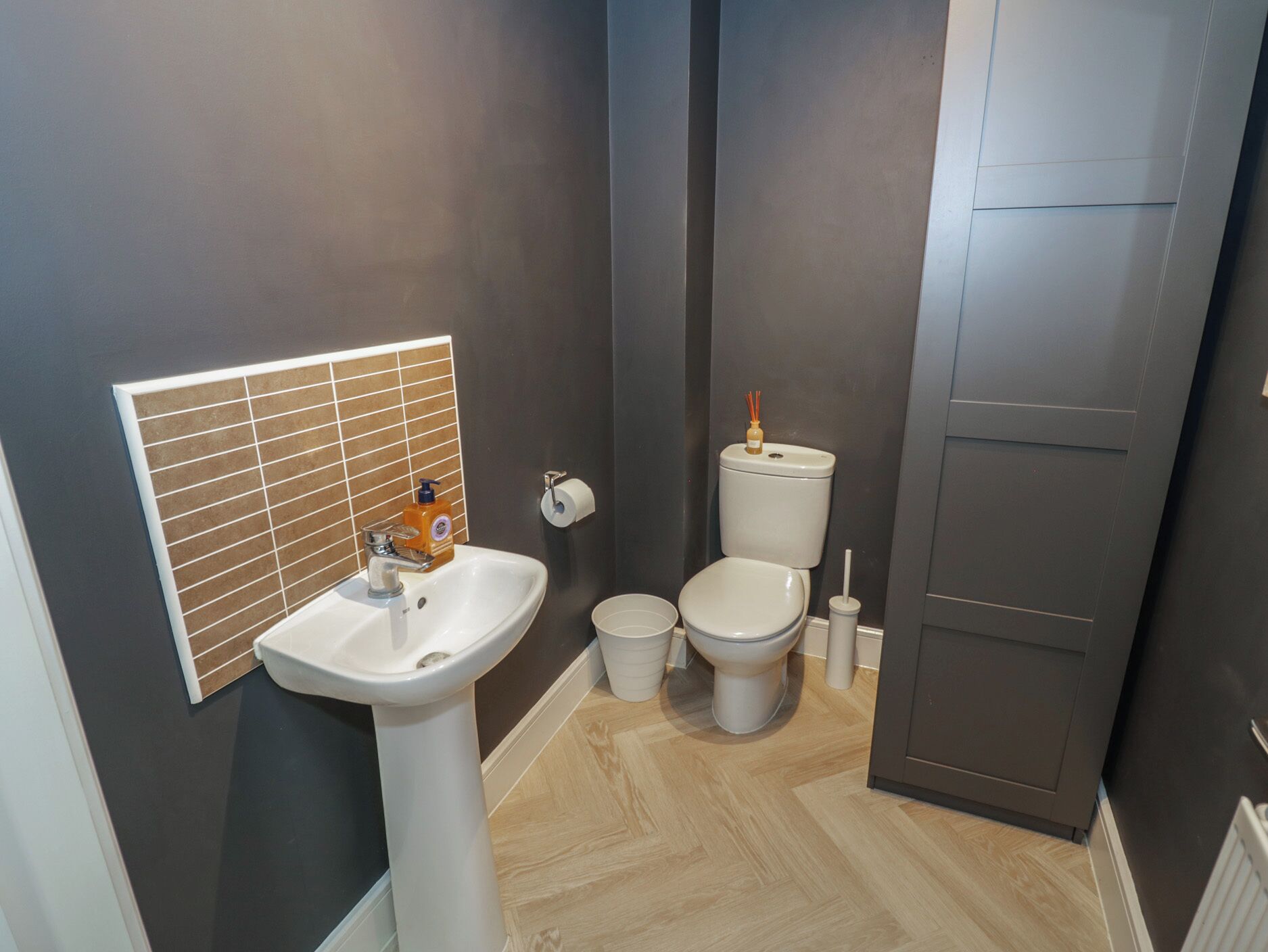 A modern bathroom with a white sink, toilet, and bidet.