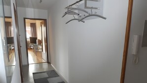 A hallway with a modern design, including a patterned floor and a metal coat rack. - Apartment 'Diepold' with Mountain View, Shared Garden and Wi-Fi (Wasserburg (Bodensee))