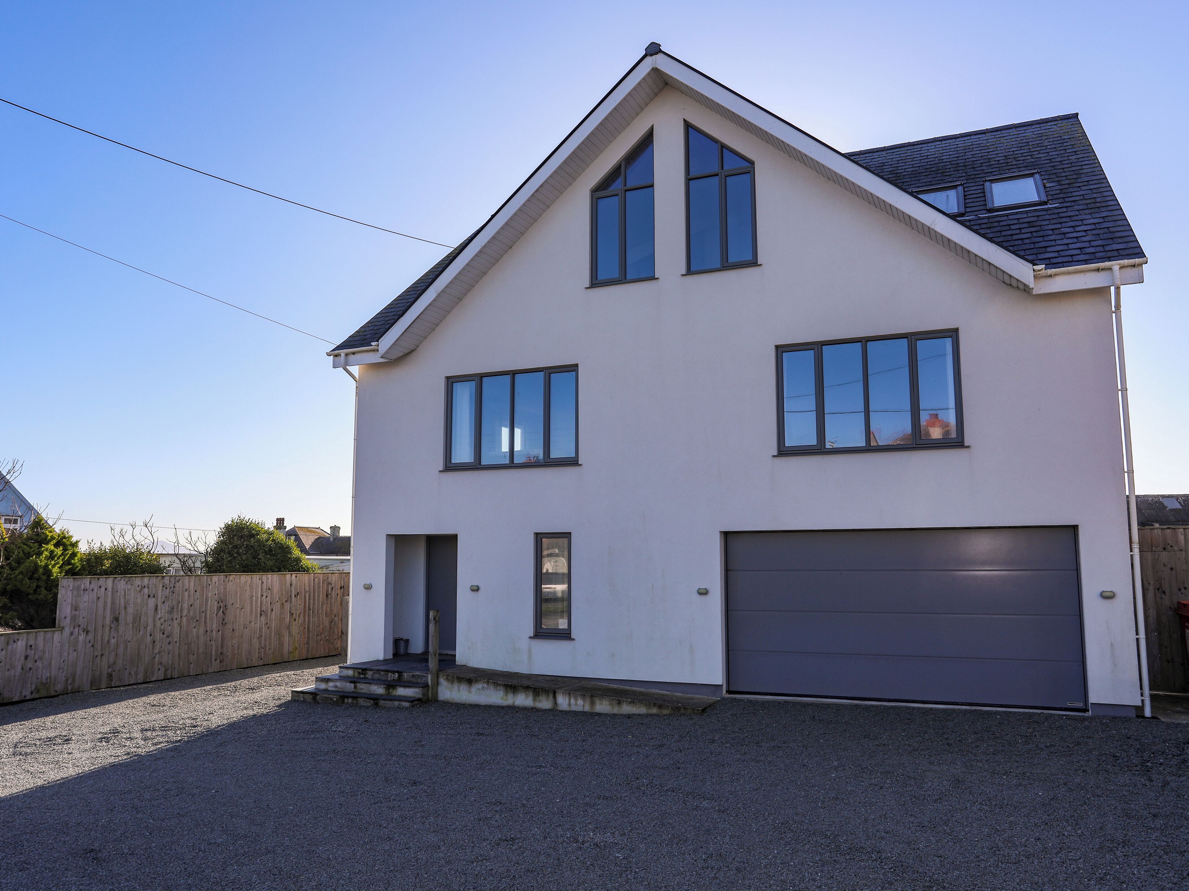 Une maison à deux étages avec un garage, une porte d’entrée et une allée.