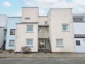A multi-story residential building with a central staircase leading to an upper entrance. - Anchor Watch (Porthmadog)