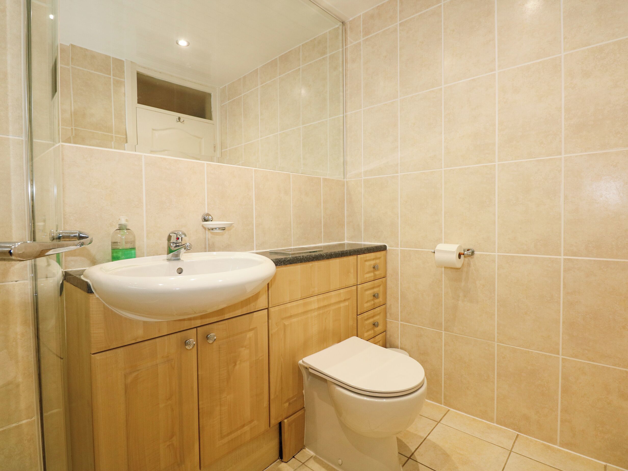 A bathroom with a sink, mirror, and toilet.