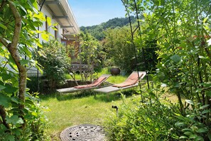 En have med swimmingpool, liggestole og en pergola.