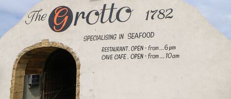 The Grotto 1782, a seafood restaurant and cave cafe with an arched entrance.