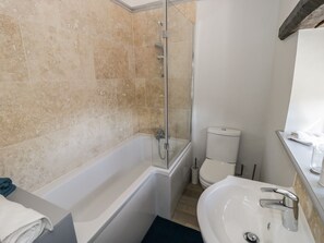 Une salle de bain équipée d’une baignoire, d’une douche, de toilettes et d’un lavabo.