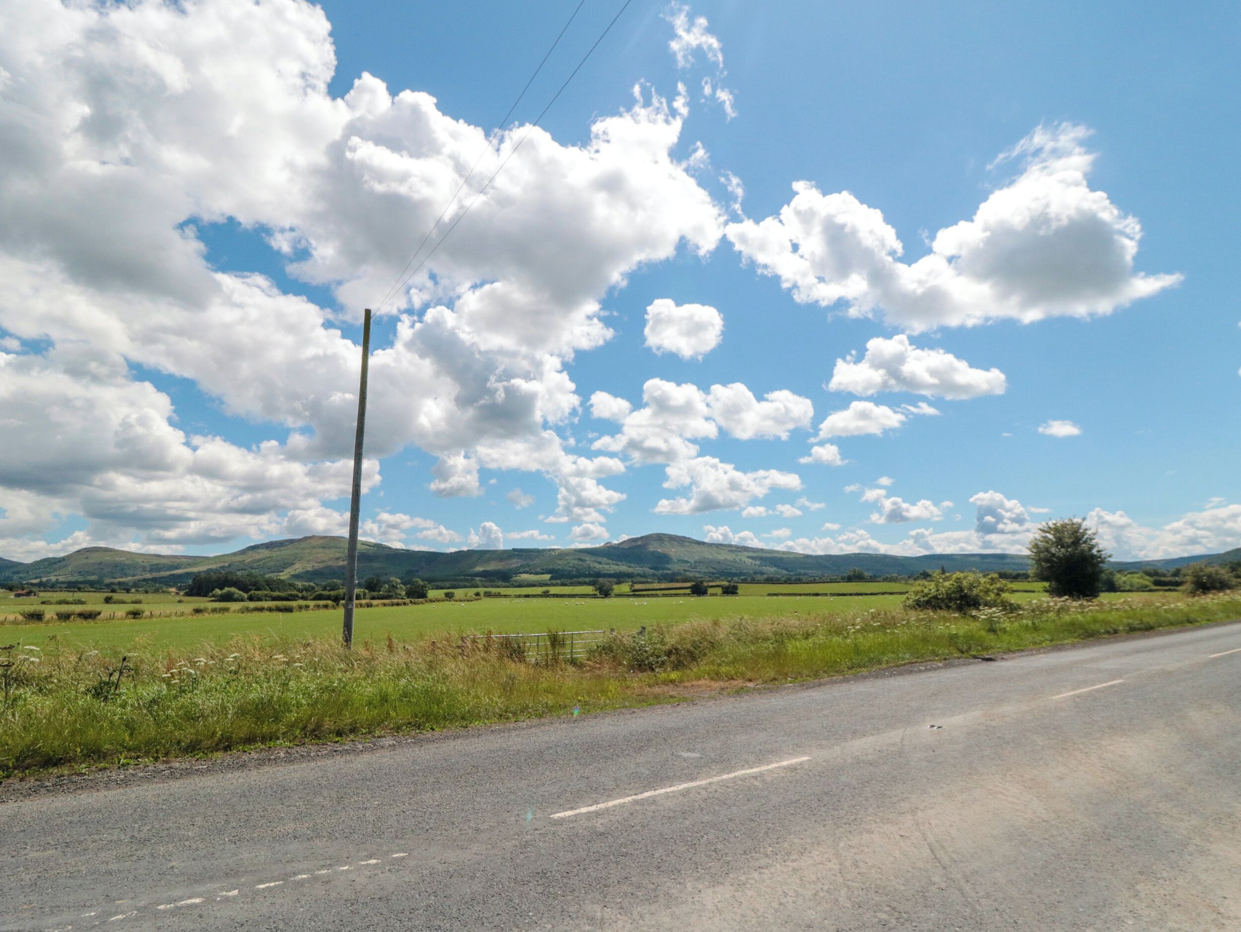 Camí rural sota un cel clar i núvols dispersos.