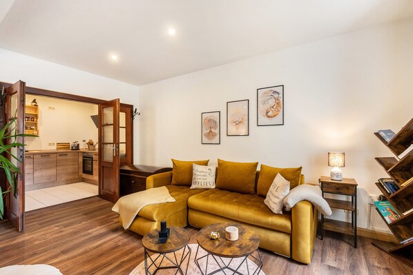 A living room with a sofa, two coffee tables, and a bookshelf.