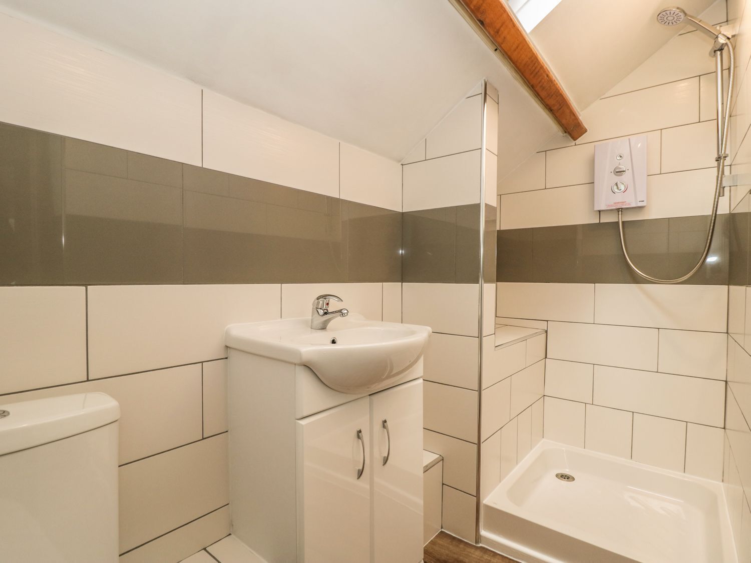 A modern bathroom with a shower, a sink, and a toilet.