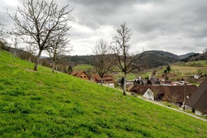 A hillside with houses, a clear sky, and a hilly landscape.