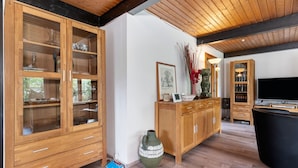 Una habitación con paneles de madera, un armario grande, un florero y un televisor.