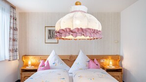 Habitación de hotel con cama, dos mesitas de noche con lámparas, una lámpara decorativa en el techo y un cuadro enmarcado en la pared.