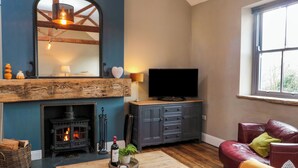 A cozy living room with a fireplace, a television, and a comfortable seating area. - Cedar Cottage (Barnard Castle)