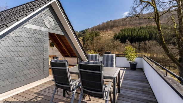 A deck with a table and chairs, overlooking a forested hillside. - Apartment 'Krähling' with Mountain View, Shared Terrace and Wi-Fi (Schmallenberg)
