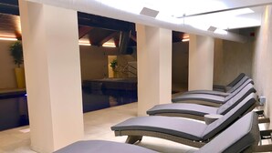 Un espace spa comprenant des chaises longues, une piscine et un comptoir d’accueil.