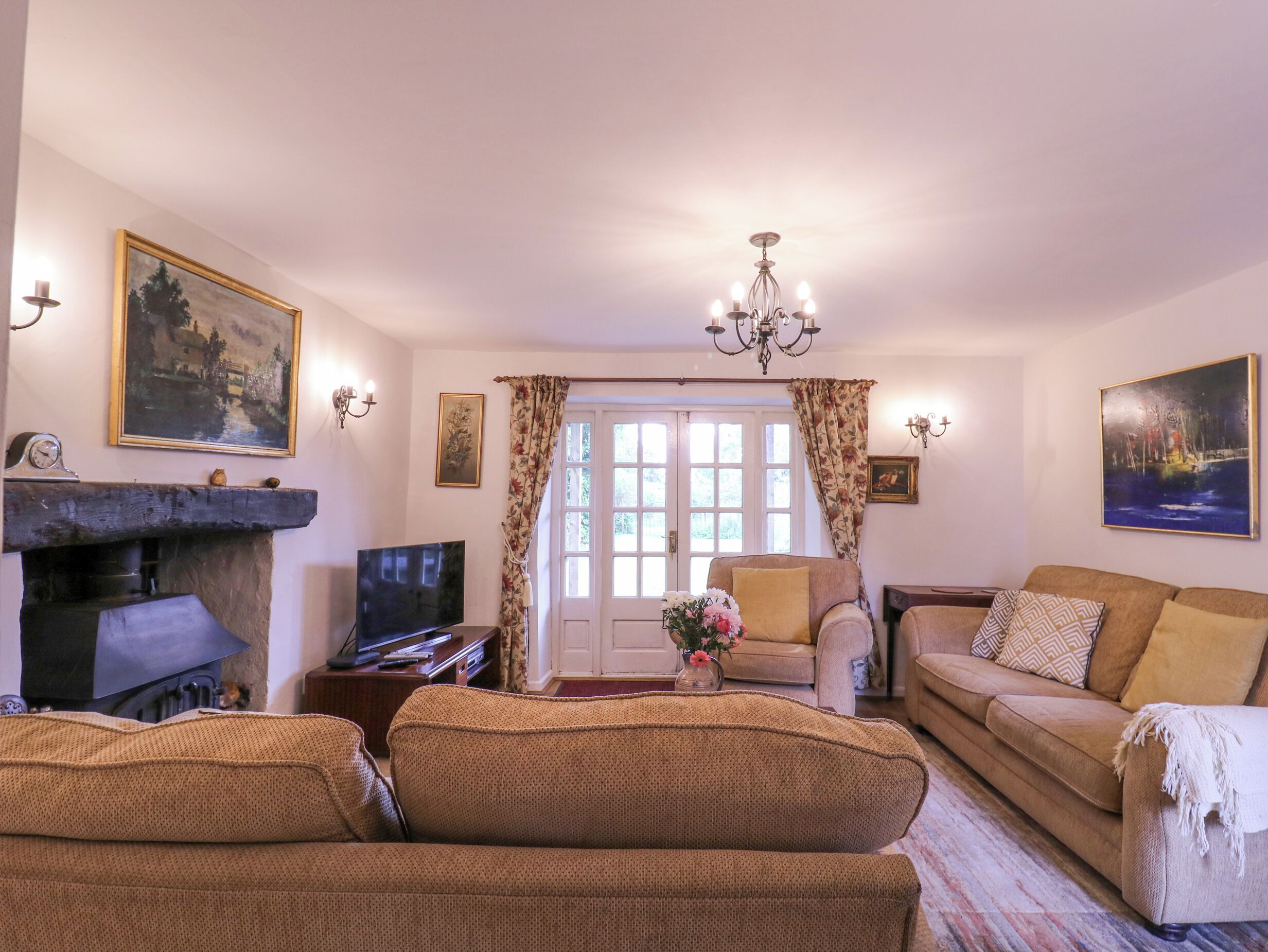 Una sala de estar acogedora con chimenea, un sofá, un televisor y una mesa de comedor.
