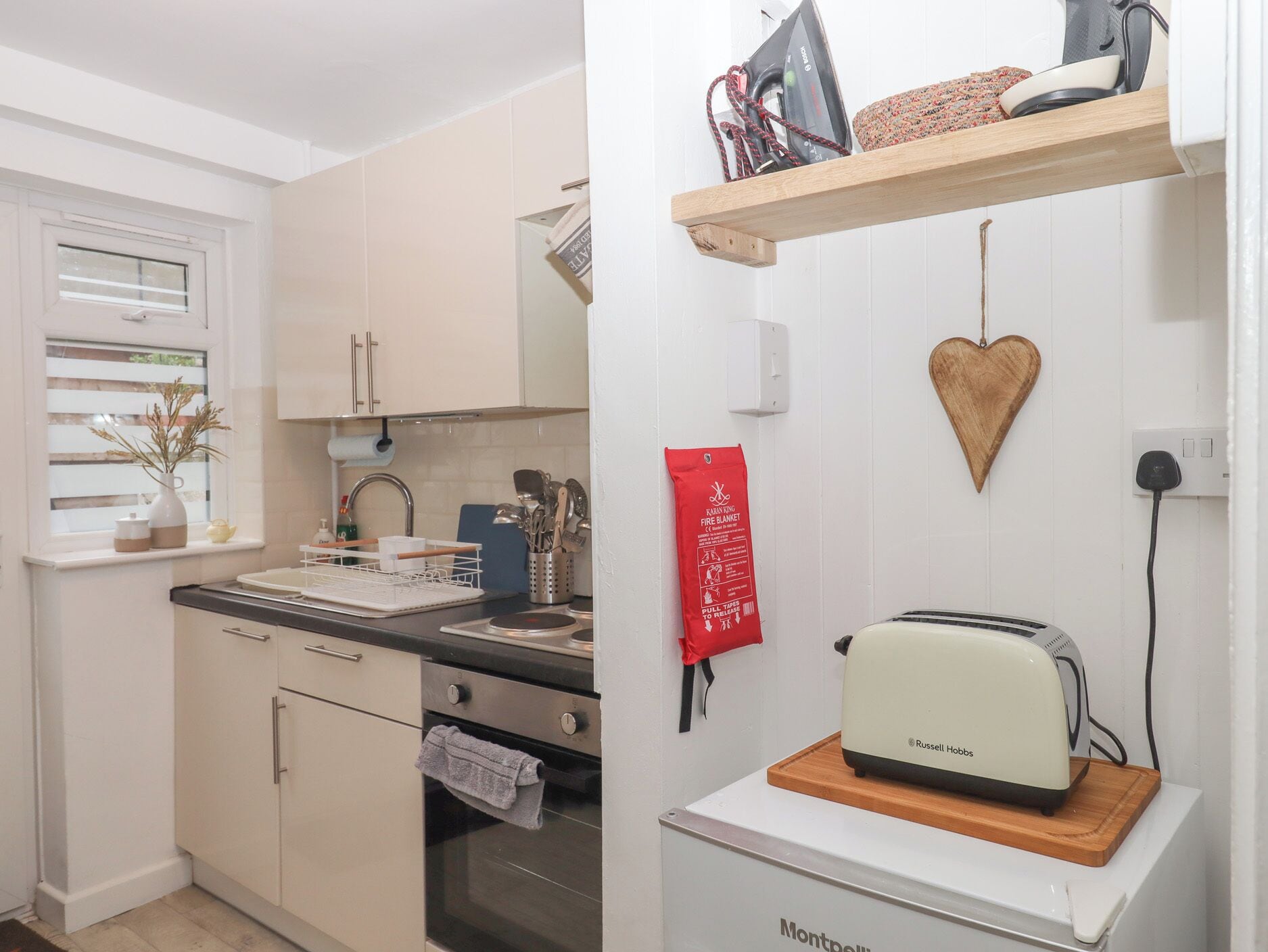 A kitchen with a wooden countertop, a toaster, and a kettle.