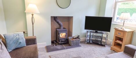 A cozy living room with a fireplace, a television, and comfortable seating.