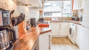 Eine moderne Küche mit Einbauwaschmaschine, Kaffeemaschine und Toaster.