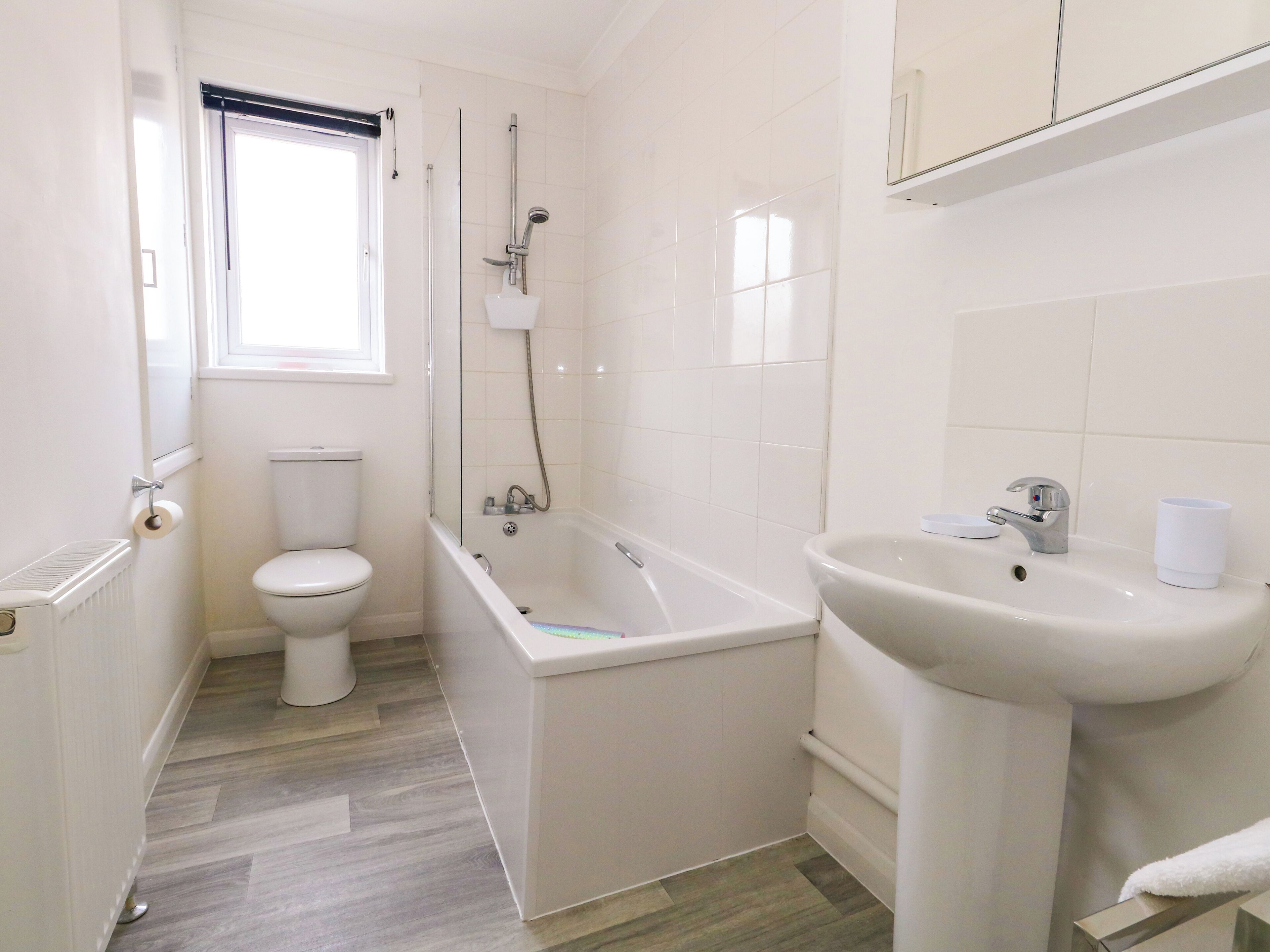 A bathroom with a toilet, a bathtub, and a sink.