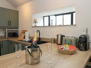 Eine moderne Küche mit einer Weinflasche in einem Eimer, Gläsern, einem Toaster und einer Kaffeemaschine.