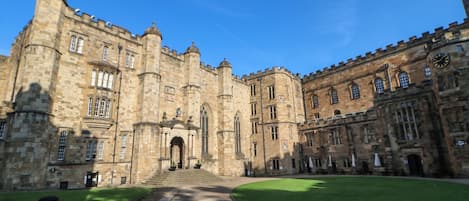 A historic stone building with a central entrance, large windows, and a symmetrical facade.