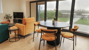 Una sala de estar moderna con un sofá, sillones, una mesa de centro y un televisor.