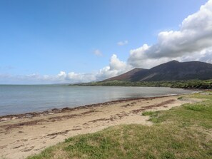 Ein Strand mit einem Berg im Hintergrund.