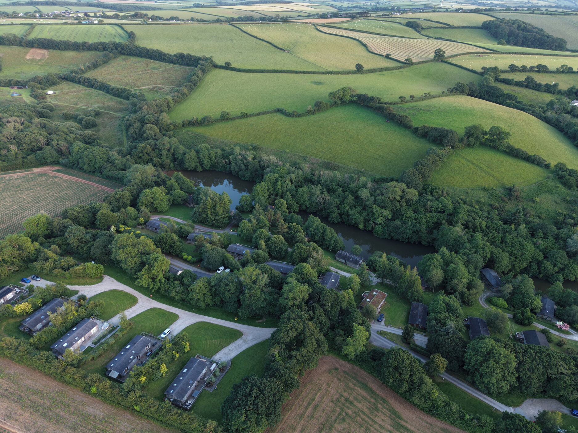 An aerial view of a residential area with houses, roads, and a river.