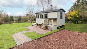 Een klein, laag huis met een veranda en een hottub in de achtertuin.