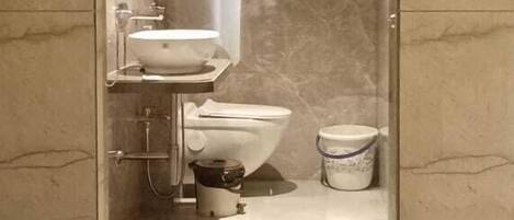 A bathroom with a built-in sink, toilet, and shower.
