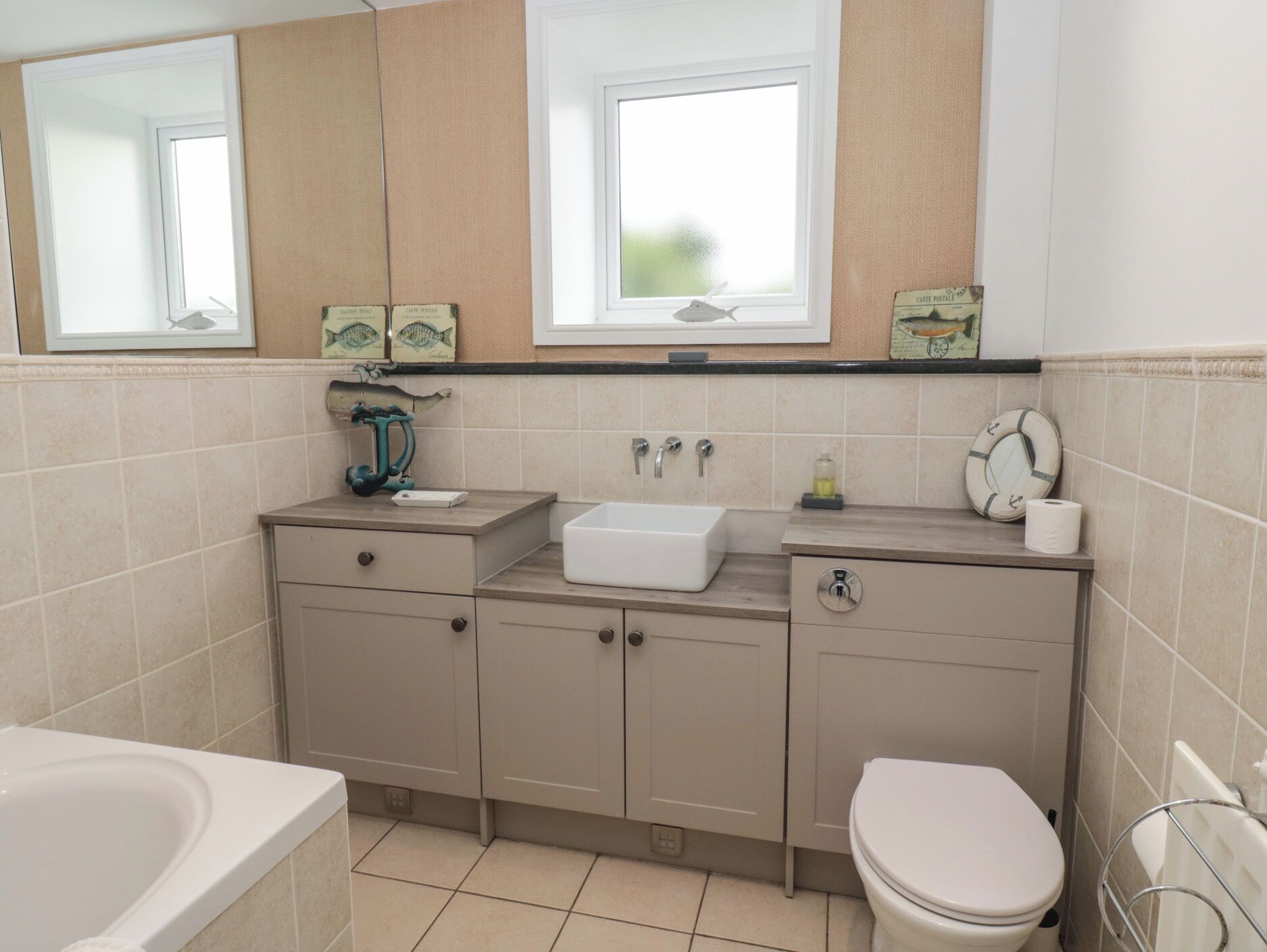 A bathroom with a bathtub, a sink, a toilet, and a window.