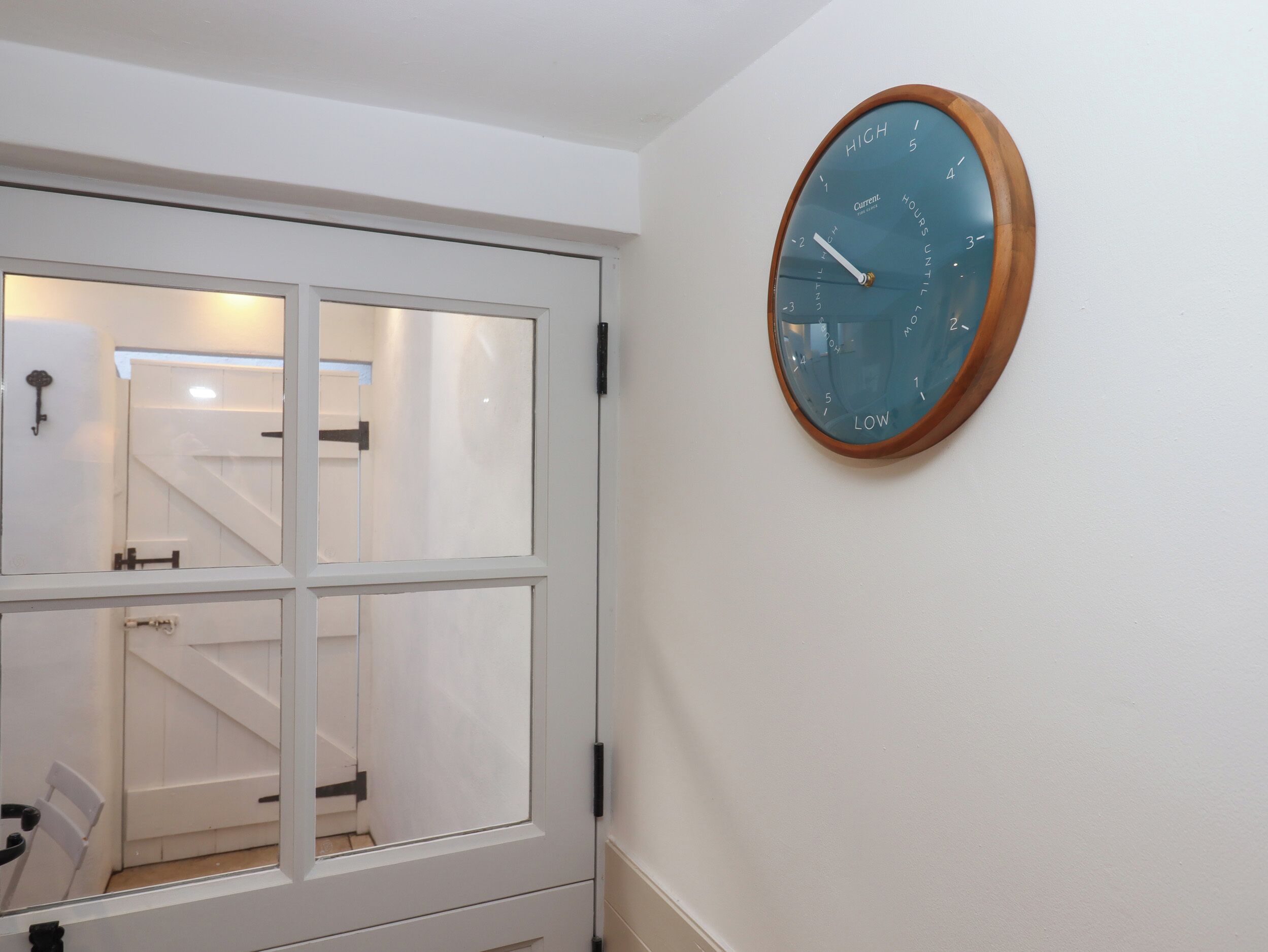 A room with a white door and a wall-mounted clock.